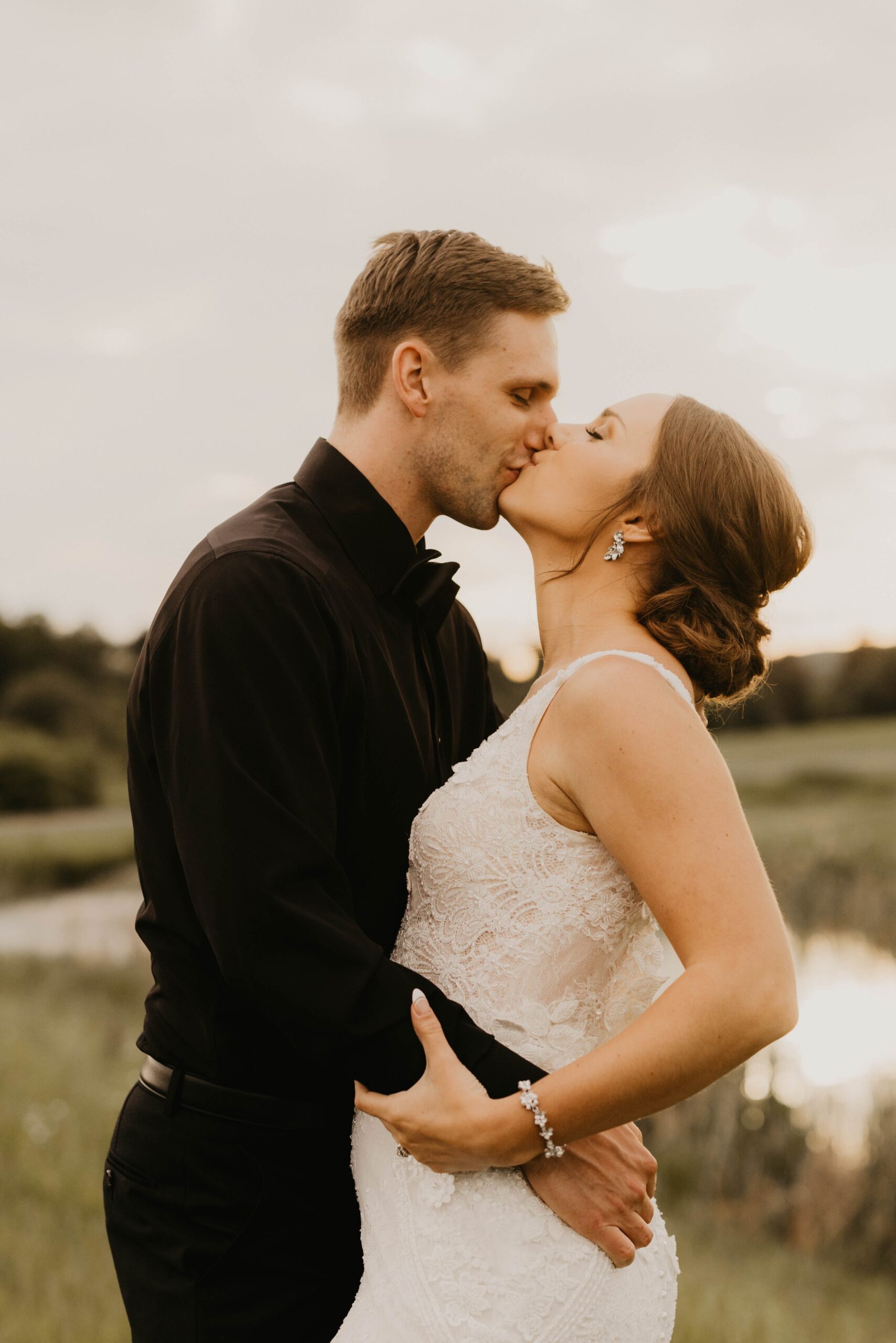 bride and groom kissing during golden hour