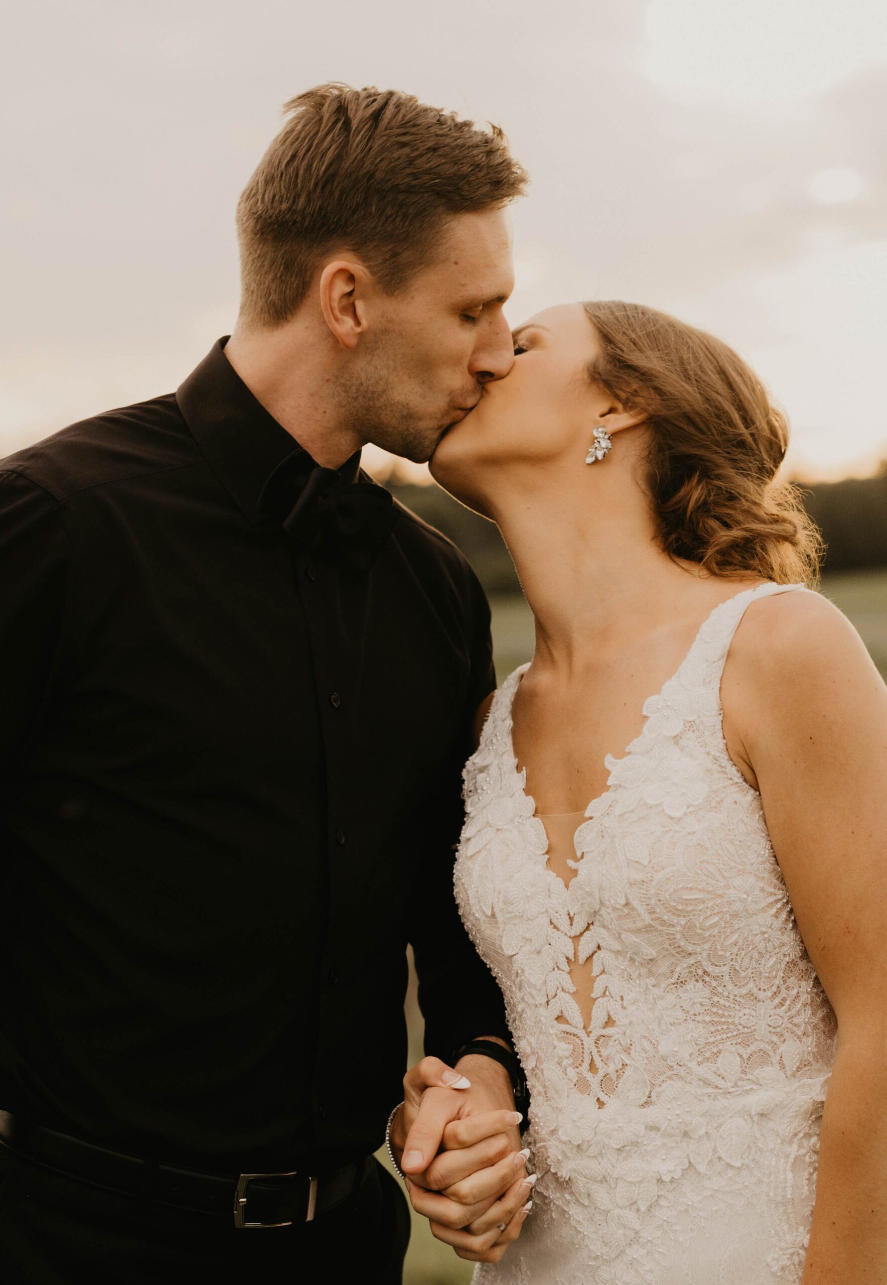 Bride and groom kissing during golden hour