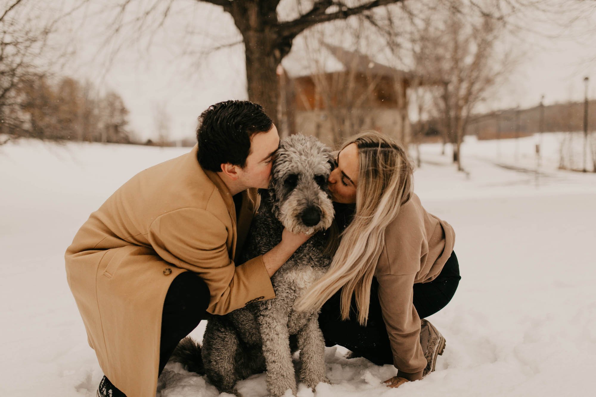 man and woman kissing their dog.jpg