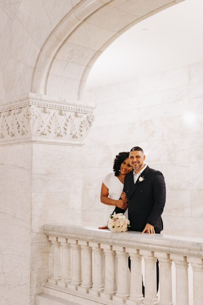 Bride and groom standing in front of marble columns at City Hall Minneapolis