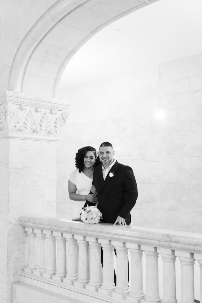 Bride and groom standing in front of marble columns at City Hall Minneapolis