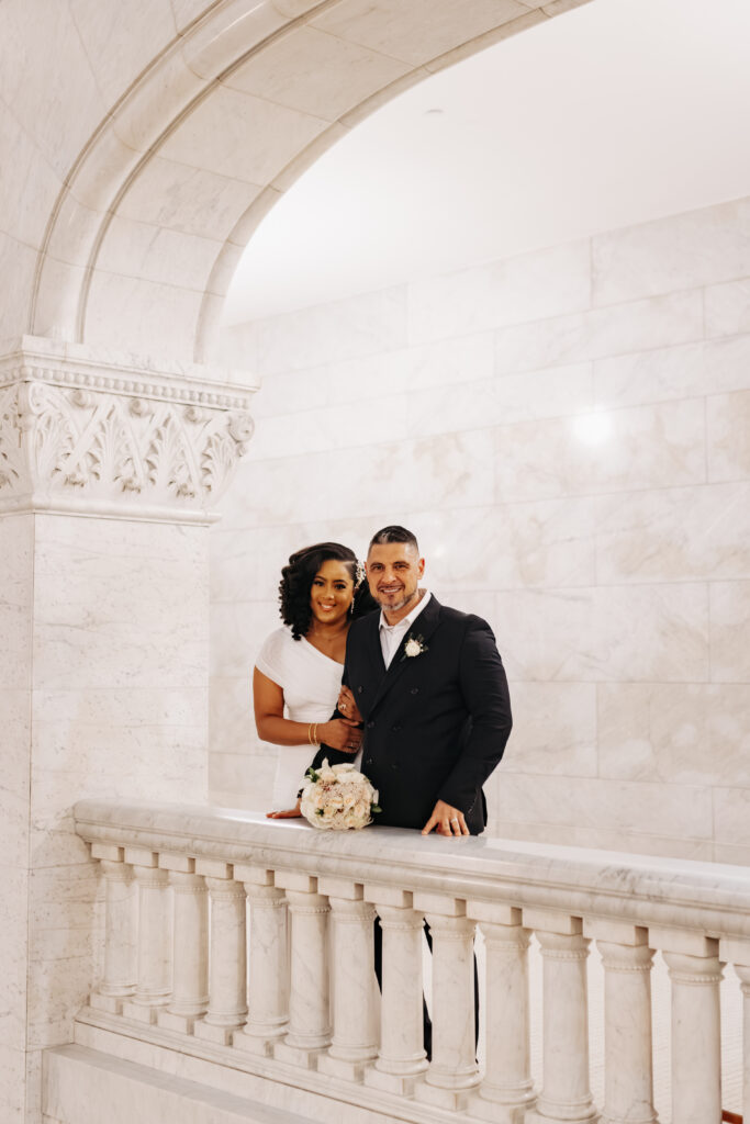 Bride and groom standing in front of marble columns at City Hall Minneapolis