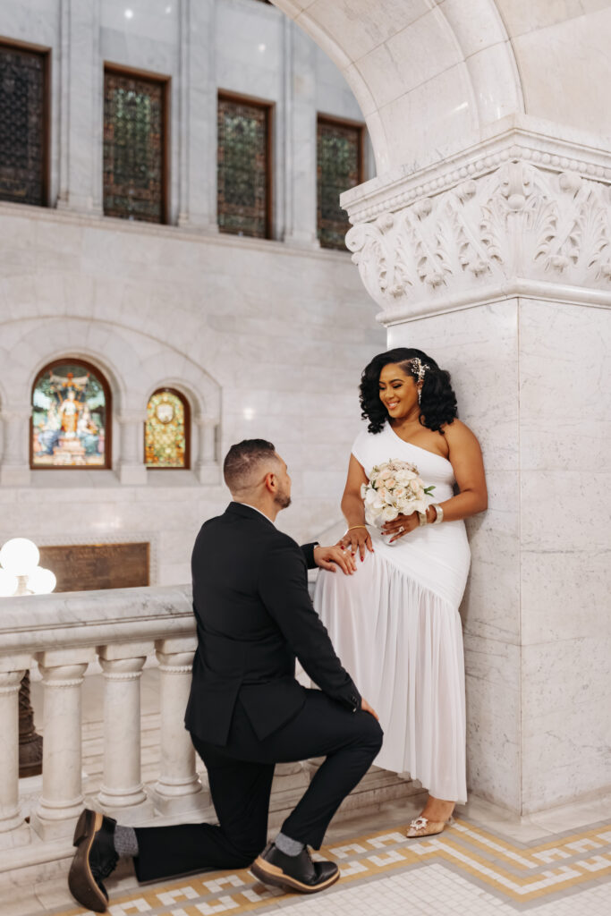 Bride and groom standing in front of marble columns at City Hall Minneapolis